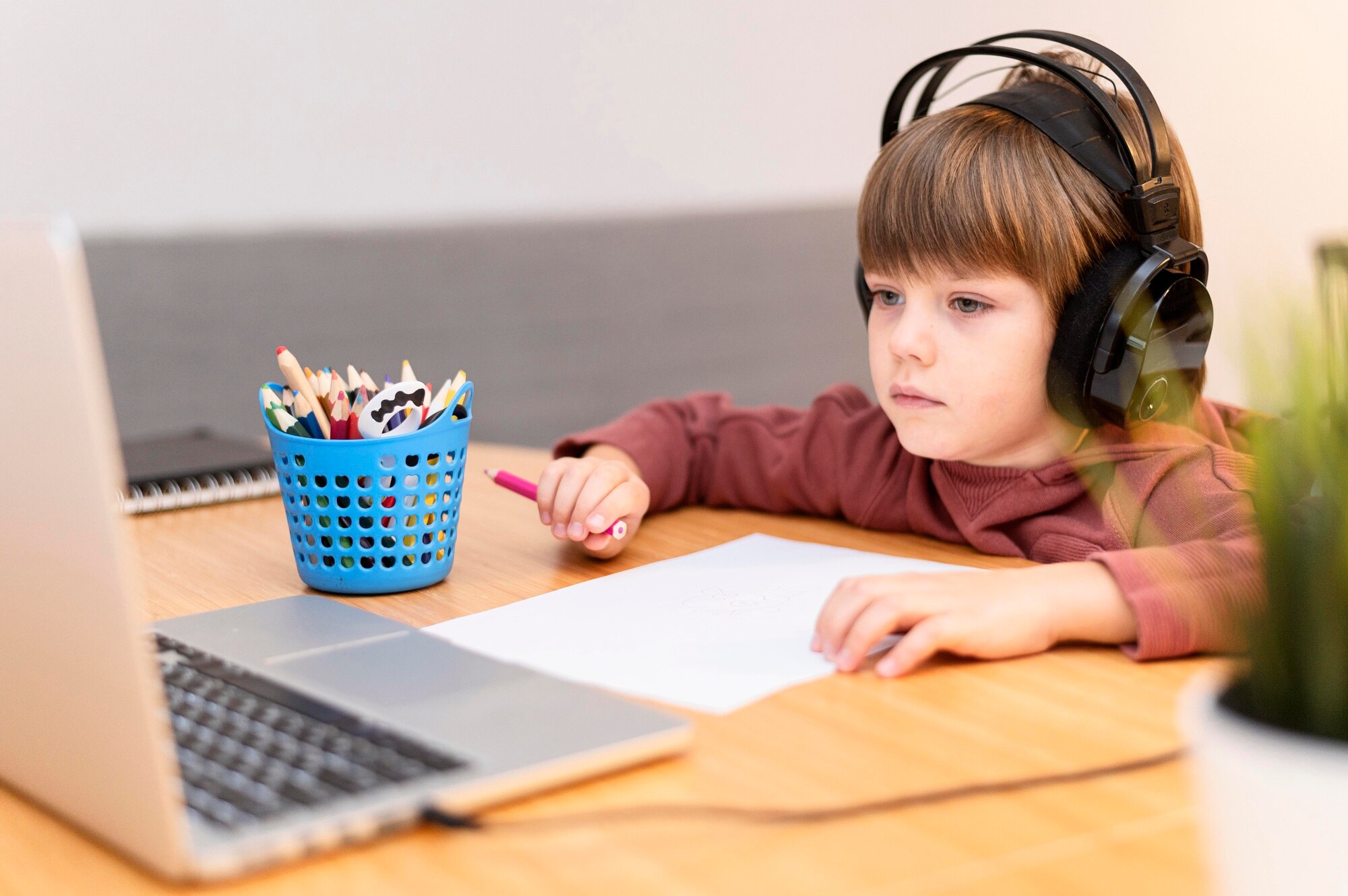 child-wearing-headphones-attending-online-school_23-2148766724